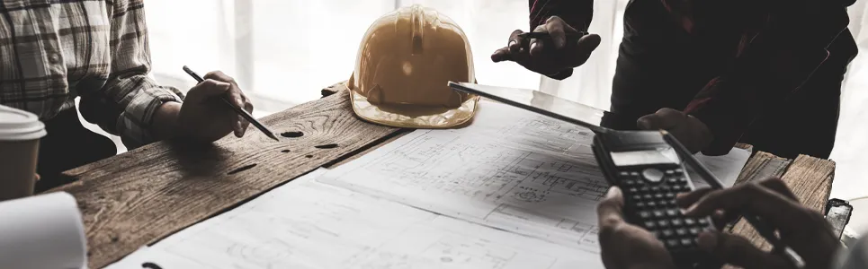 construction contractors looking at time tracking app over a set of blue prints