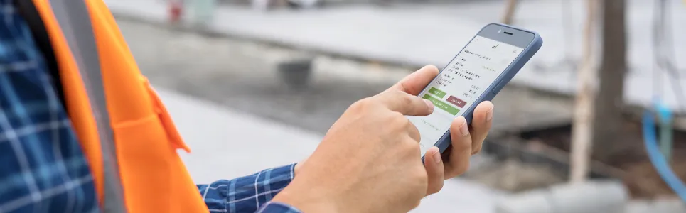 a construction worker using a mobile time trackcing app on his iPhone
